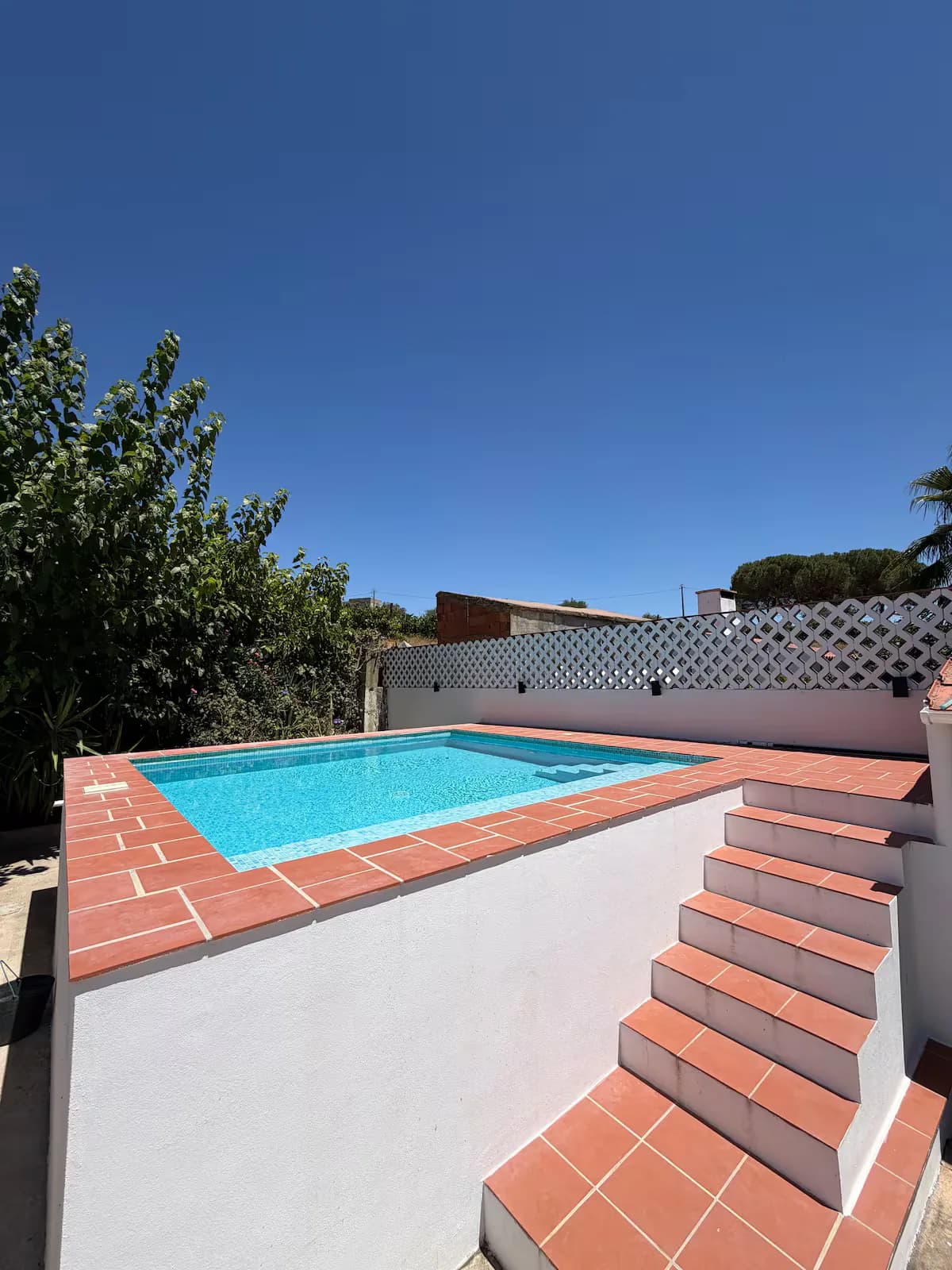 Terracotta steps down to the pool