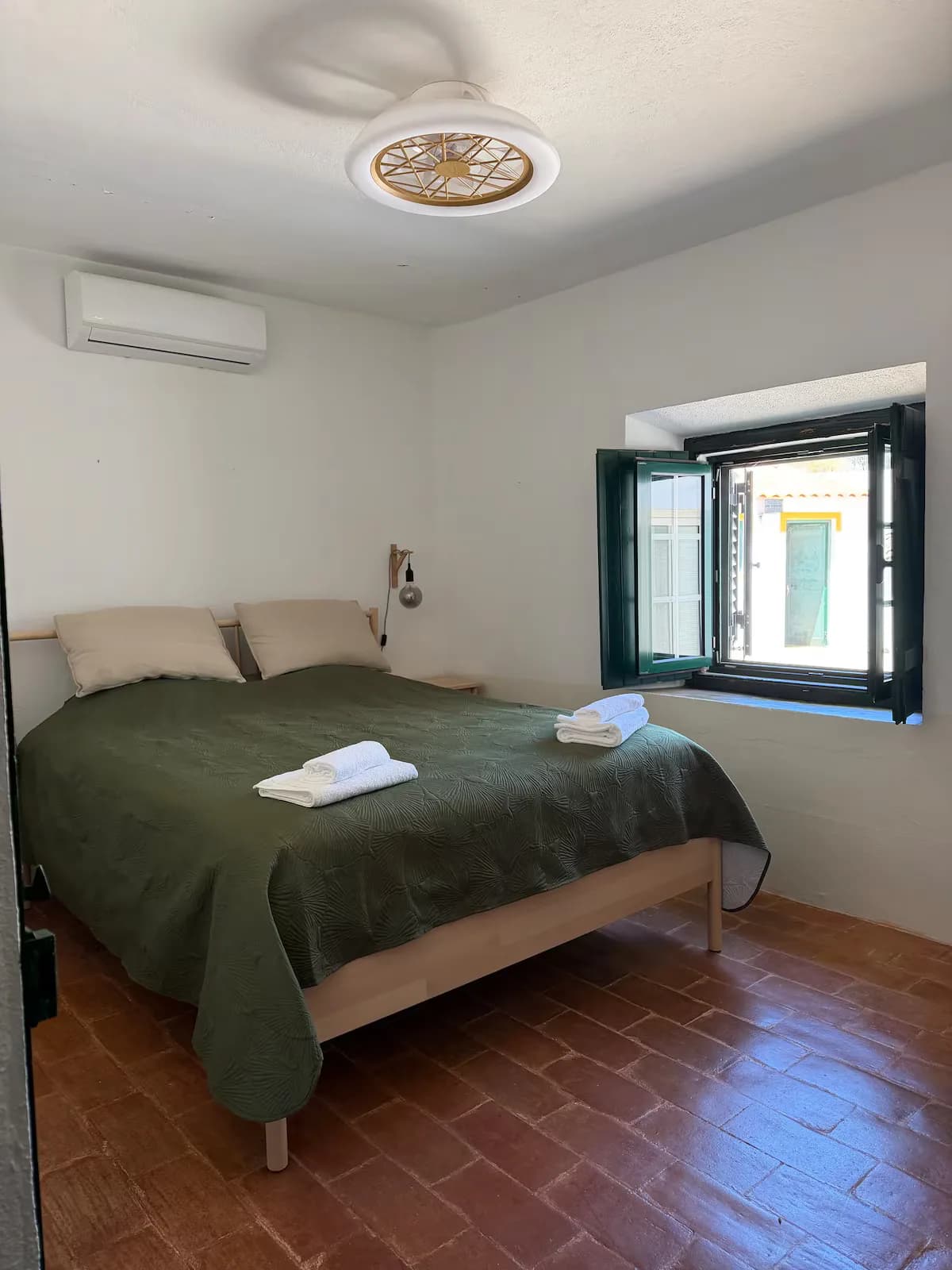 Double bedroom with a green bedspread and ceiling fan